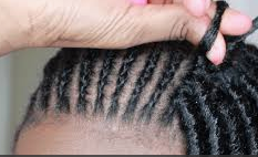 Image of someone adding dreadlock extensions using the crochet method.