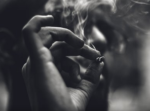 A close-up picture of a person smoking a joint.