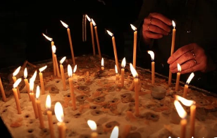 A pair of hands lighting candles.