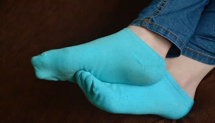 Pair of feet in blue socks tightly clutched together.