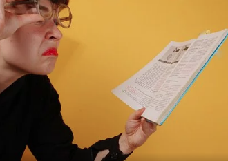 Mature lady lifting her glasses while fiercely examining a document.
