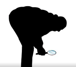 Silhouette of man looking at the ground with a magnifying glass.